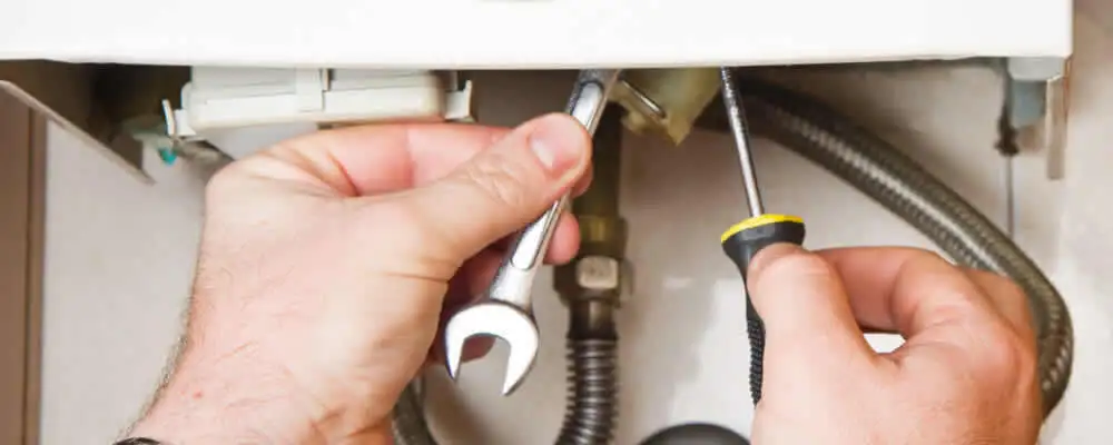 Boiler repair technician tightening pipe fittings and connections in Chicago, IL