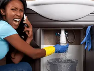 Emergency plumbing repair for a leaking sink drain under a bathroom vanity in Chicago, IL