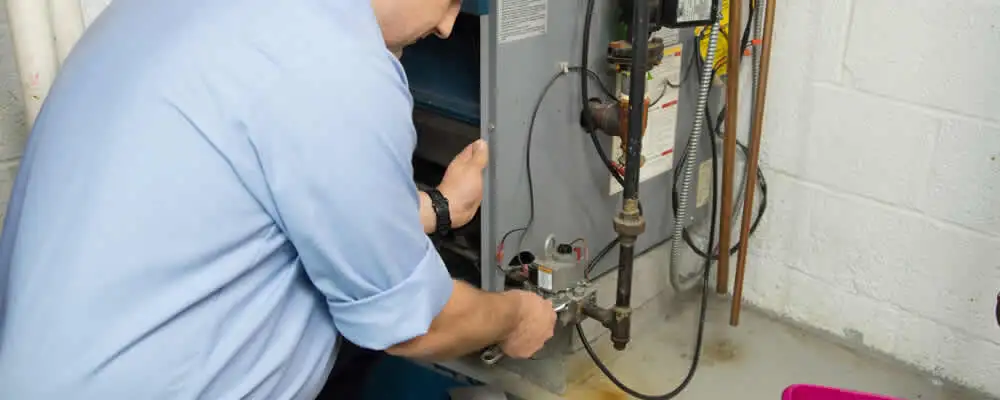 Furnace repair technician inspecting and servicing a home heating system in Chicago, IL