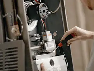Furnace repair technician inspecting internal components and wiring in Chicago, IL