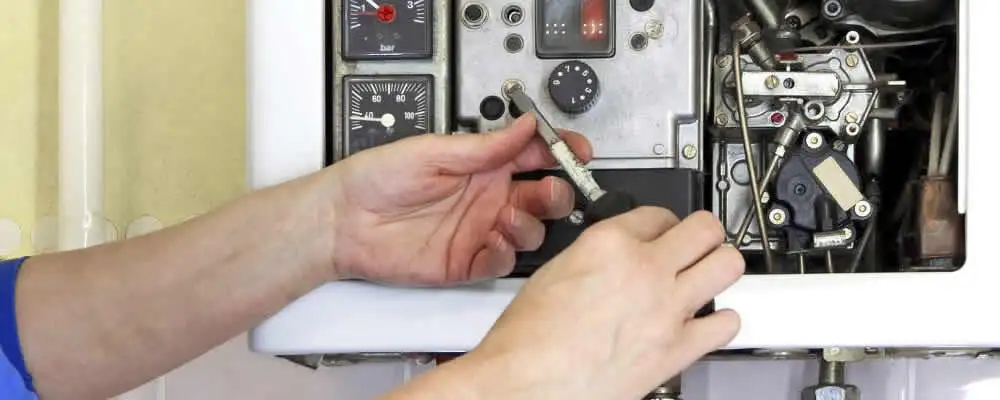 Heating repair technician adjusting boiler controls and components in Chicago, IL