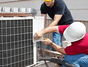 HVAC technicians repairing an outdoor AC unit on a rooftop in Chicago, IL