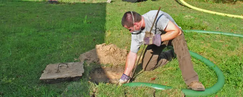 Septic pumping technician servicing a residential septic tank in Chicago, IL