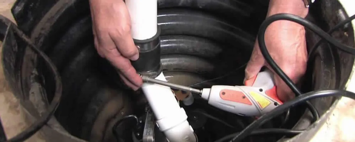 Sump pump installation technician connecting PVC discharge piping in Chicago, IL