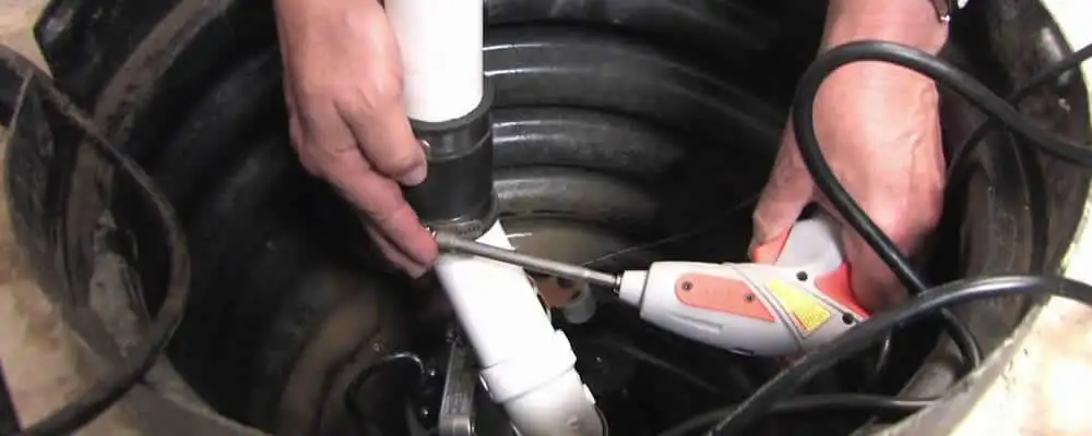 Sump pump installation technician connecting PVC discharge piping in Chicago, IL
