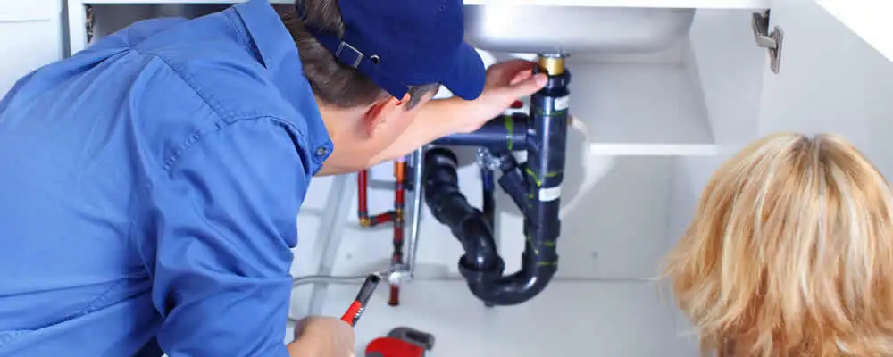 Plumber repairing under-sink drain pipes and fittings in Chicago, IL